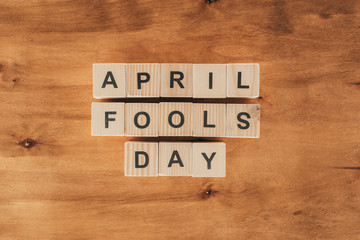 top view of arranged wooden cubes in april fools day lettering on wooden tabletop, 1 april holiday...