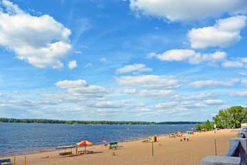 Fototapeta na wymiar Samara, people on city beach on the shores of the Volga River. beautiful cumulus clouds on blue sky