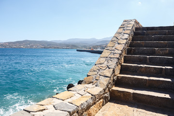 Fototapeta premium Stone staircase to the sea with mountains in the background