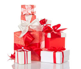 Heap of bright gift boxes decorated with red and white bows isolated on white