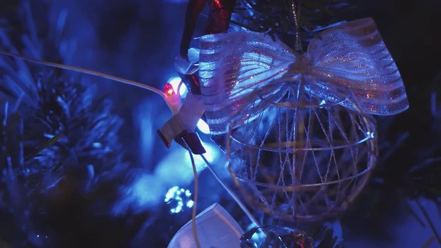 New Year's toy, electric garland glows on the Christmas tree, close-up