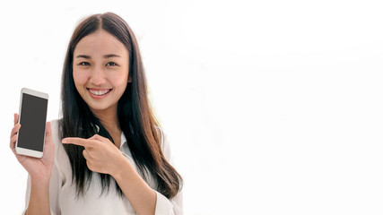 Naklejka premium Young beautiful female hold and point at smartphone isolated on white background