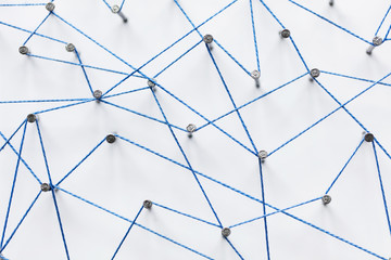 A large grid of pins connected with string. Communication, technology, network concept