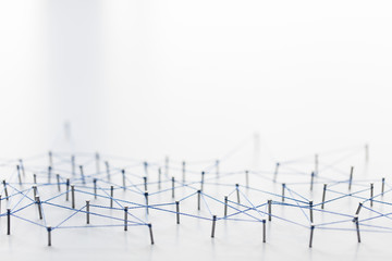 A large grid of pins connected with string. Communication, technology, network concept