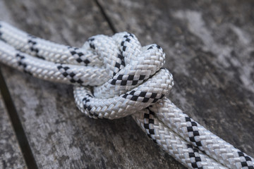 Rope knot on a teak wood background.