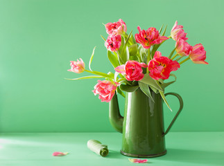 beautiful pink tulip flowers bouquet in green tea pot