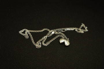 A silver chain, on a black background.
