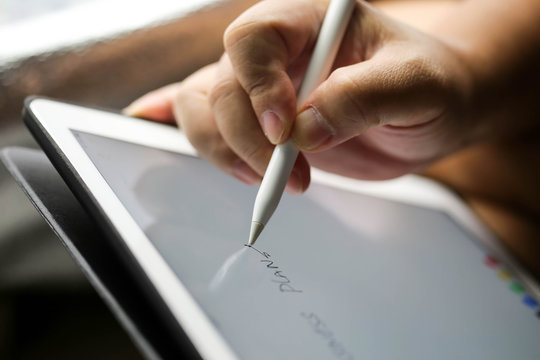 Businessman writing touch pad on wording Business.