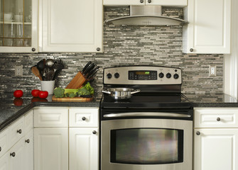 Electric Stainless steel stove, kitchen utensils and vegetables on the cooking table © Anjelika Gretskaia