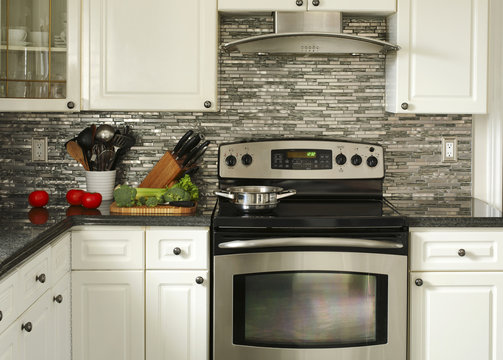 Electric Stainless steel stove, kitchen utensils and vegetables on the cooking table