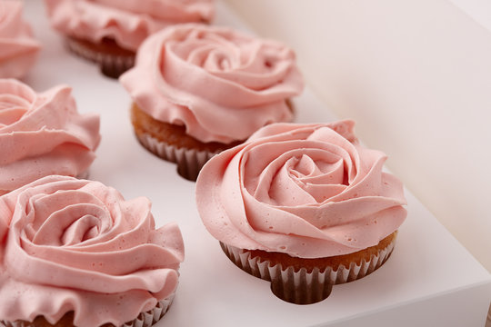 Muffins or cupcakes with flower shaped cream in box, close up view