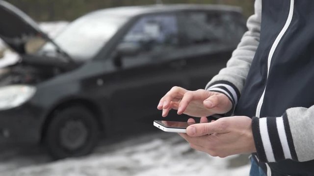 Man uses the phone after the car has broken down