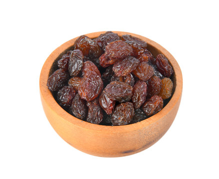 Black raisin on wood bowl isolated on white background