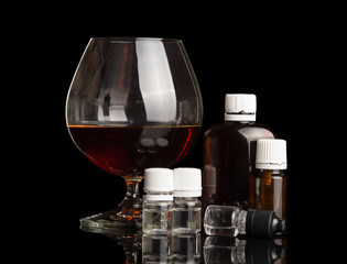 Glass with alcohol, set of liquids for smoking an electronic cigarette, isolated on black