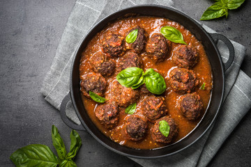 Meatballs in tomato sauce on a black background. 