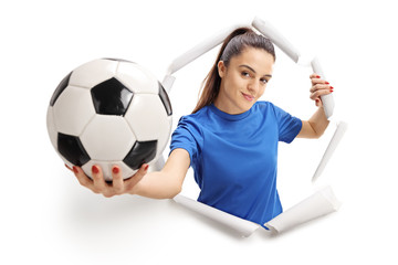 Female soccer player breaking through paper