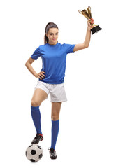 Female soccer player with a football and a golden trophy
