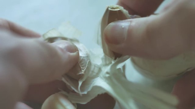 man is cleaning garlic close-up cloves. Vegetarians garlic food in the kitchen lifestyle indoors