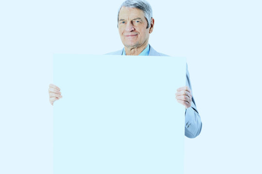 Nice businessman at the age holds white poster