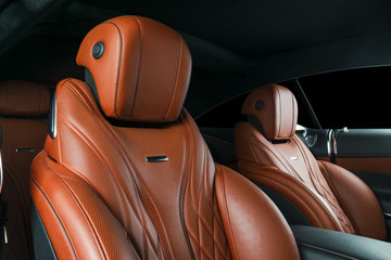 Modern Luxury car inside. Interior of prestige modern car. Comfortable leather red seats. Orange...