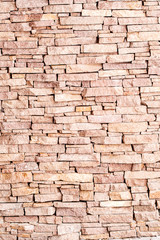 textured background made of light red stones wall