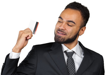 Happy smiling young man holding a credit card isolated on white background