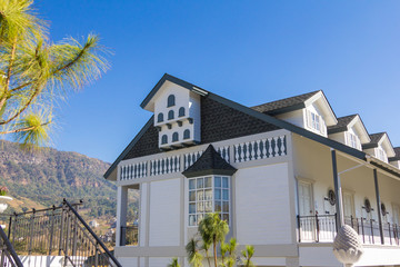 The roof of the house with beautiful window in the blue sky background.
