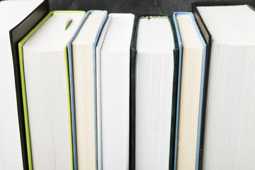 Pile of various books on dark background