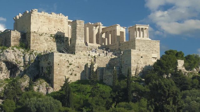 The Acropolis Ruins with Tourists. The Acropolis is one of the most important ancient monuments in the world with archaeological structures including: The Acropolis, Erechtheion, Parthenon, Propylaea.