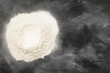 Flour on dark background. Top view, copy space. Food background