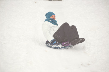 Belarus, Grodno, Lake Molochnoe in the winter. People sledding on the slides.