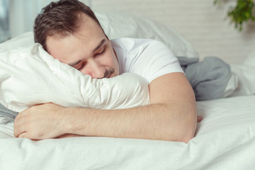 Young Man Sleeping On Bed In Bedroom