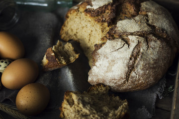 Loaf of rye bread with chicken eggs in wooden box