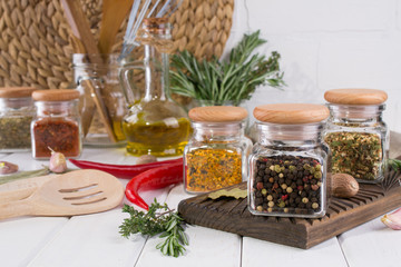 Composition of kitchen tools, spices and herbs on white table