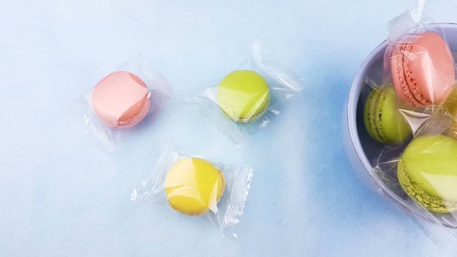 Sweet color macaroons or macaron in plate on pastel surface. Close up.