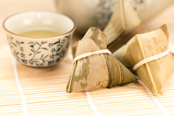 Fototapeta premium Zongzi or Traditional Chinese Sticky Rice Dumplings on Wooden Placemat