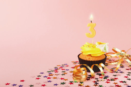 Third birthday cupcake with candle and sprinkles