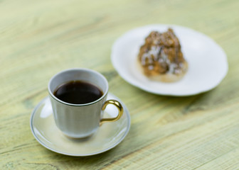 Coffee in a retro cup and cake on a wooden background.
