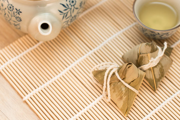 Fototapeta na wymiar Zongzi or Traditional Chinese Sticky Rice Dumplings on Wooden Placemat