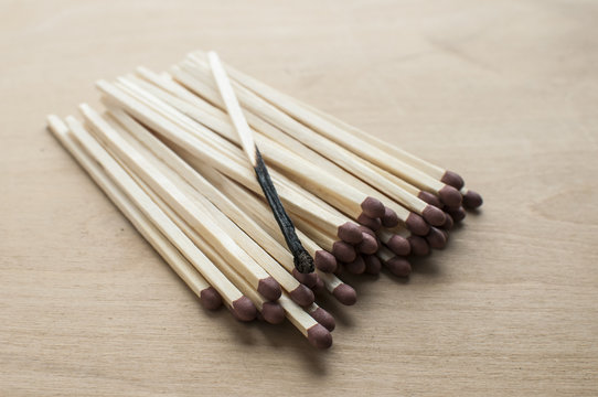 Burnt and whole head long wooden safety matchsticks on wooden background