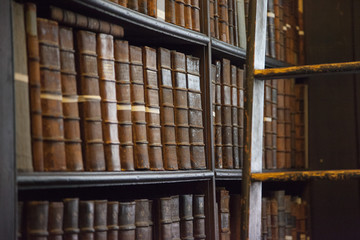 Old books in bookshelves in library
