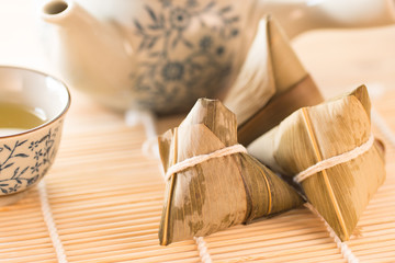 Zongzi or Traditional Chinese Sticky Rice Dumplings on Wooden Placemat