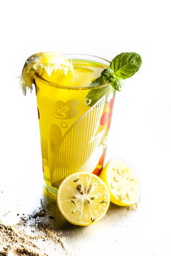 Close up of Indian most popular summer drink Nimbu pani or Nimbo sarbat,Lemonade in a transparent glass with salt and black pepper.Isolated on a white surface.