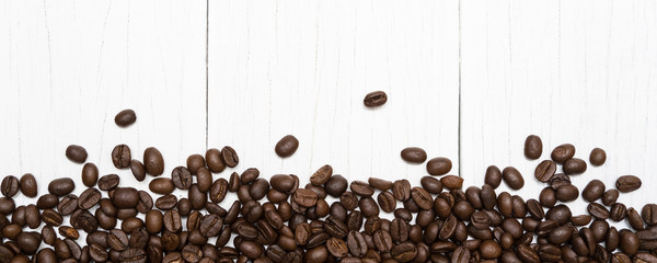 Roasted of coffee beans on white wood background.