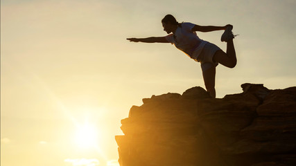 woman yoga on mountain summit at sunset