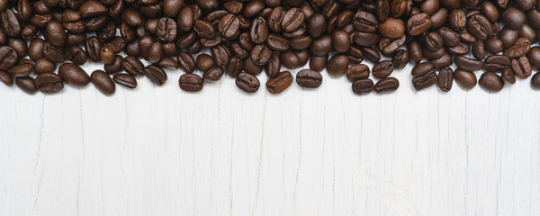 Roasted of coffee beans on white wood background.