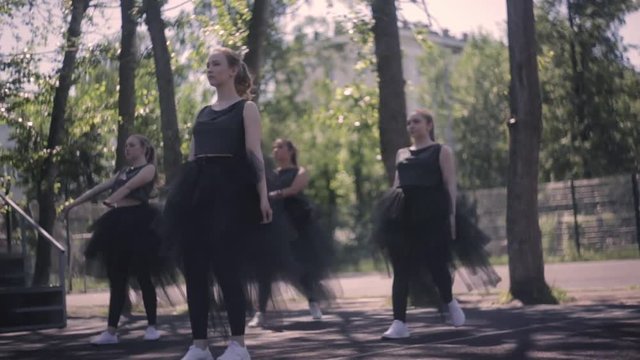 Dance of beautiful girls in suits on a summer warm day