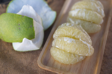 Sliced pomelo on wooden tray
