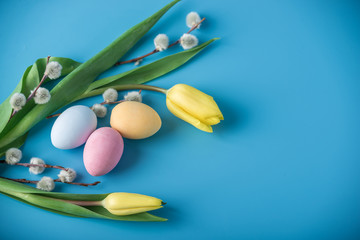 Colorful Easter eggs with yellow Tulip hand painted on a blue background. Holiday spring card