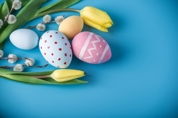Colorful Easter eggs with yellow Tulip hand painted on a blue background. Holiday spring card
